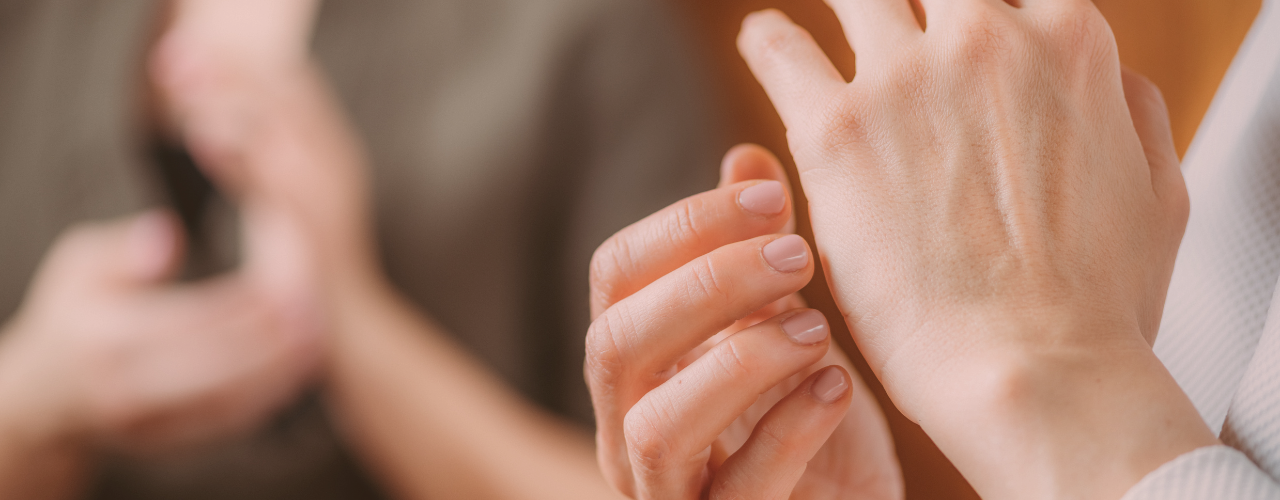 Woman practicing EFT tapping on the side of her hand, symbolizing emotional healing.
